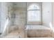 Bathroom boasts walk-in shower and tub with lots of natural light coming from an arched window at 2660 Portabella Ln, Cumming, GA 30041