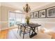 Formal dining room with natural light, neutral colors, hardwood floors, and modern chandelier at 2660 Portabella Ln, Cumming, GA 30041