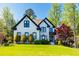 Beautiful two-story home with a lush front lawn, manicured shrubs, and trees at 2660 Portabella Ln, Cumming, GA 30041