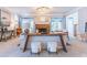 Living room featuring a stone fireplace, chandelier, and natural light, with a sofa table providing extra seating at 2660 Portabella Ln, Cumming, GA 30041