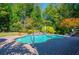 Private backyard pool with brick surround, mature trees, and charming waterfall feature at 2660 Portabella Ln, Cumming, GA 30041