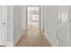 Hallway with hardwood floors and neutral walls leading into a room with a large window at 408 Vinca Nw Cir, Kennesaw, GA 30144