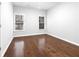 Empty bedroom with hardwood floors, white walls, and two windows with natural light coming through at 4305 Riverglen Cir, Suwanee, GA 30024