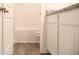 Bathroom with vinyl flooring, featuring a shower-tub combo and granite countertops on white cabinets at 651 Egrets Landing #53, Covington, GA 30014