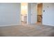 A bedroom with a carpeted floor offers a view of the bathroom and hallway, creating an open and inviting space at 651 Egrets Landing #53, Covington, GA 30014