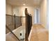 Upstairs hallway featuring wood and metal railing and neutral carpeting at 651 Egrets Landing #53, Covington, GA 30014