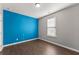 Bedroom with modern decor, including a vibrant blue accent wall, paired with neutral grays for a balanced aesthetic at 7995 Brewton Creek Dr, Cumming, GA 30028