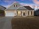 Inviting two-story home featuring a brick facade, attached garage, and manicured lawn under a twilight sky at 7995 Brewton Creek Dr, Cumming, GA 30028