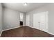 Open Primary bedroom featuring hardwood floors, ensuite bathroom entrance, and closet with double doors at 7995 Brewton Creek Dr, Cumming, GA 30028