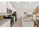 Modern kitchen featuring stainless steel appliances, granite countertops, a kitchen island, and an open floor plan at 537 Tuskegee St # 48, Mcdonough, GA 30252