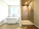 Bathroom showcasing a modern soaking tub and a stylish glass-enclosed shower at 642 Egrets Landing #66, Covington, GA 30014