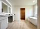 Primary bathroom featuring double sinks, modern vanity, and a relaxing soaking tub at 642 Egrets Landing #66, Covington, GA 30014