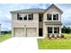 Two-story brick home featuring a two-car garage, lush lawn, and dark shutters at 642 Egrets Landing #66, Covington, GA 30014