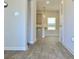 Bright hallway with wood-look flooring leading to a kitchen with stainless steel appliances at 642 Egrets Landing #66, Covington, GA 30014