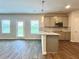 Open-concept kitchen featuring an island with sink, stainless appliances, and natural light at 642 Egrets Landing #66, Covington, GA 30014