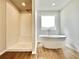Elegant bathroom with a soaking tub beneath a window and a separate tiled shower at 642 Egrets Landing #66, Covington, GA 30014