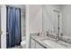 Bright bathroom featuring granite countertops, vanity with mirror and shower with blue curtain at 642 Egrets Landing #66, Covington, GA 30014