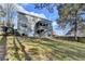 The back of the house features an enclosed porch, stairs, and lush lawn at 1229 Woodmere Dr, Loganville, GA 30052