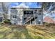 Back of the house with enclosed back porch, stairs to the porch, and lawn at 1229 Woodmere Dr, Loganville, GA 30052