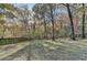 Expansive backyard with mature trees and a wooden fence, perfect for outdoor activities at 1229 Woodmere Dr, Loganville, GA 30052