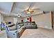 Finished basement with a large sectional couch, carpet, and multiple ceiling fans at 1229 Woodmere Dr, Loganville, GA 30052