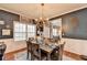 Dining room with modern chandelier, large window, and dining table with seating for six at 1229 Woodmere Dr, Loganville, GA 30052