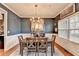 Elegant dining room with wainscoting, modern chandelier, and a dining table with six chairs at 1229 Woodmere Dr, Loganville, GA 30052