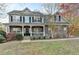 Charming two-story home with stone accents, a welcoming front porch, and landscaped front yard at 1229 Woodmere Dr, Loganville, GA 30052