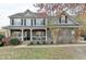 Charming two-story home with stone accents, a welcoming front porch, and landscaped front yard at 1229 Woodmere Dr, Loganville, GA 30052