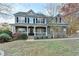 Charming two-story home with stone accents, a welcoming front porch, and landscaped front yard at 1229 Woodmere Dr, Loganville, GA 30052