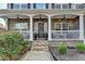 Inviting front porch with stone columns and welcome decor, offering a warm entrance to the home at 1229 Woodmere Dr, Loganville, GA 30052