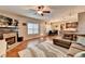 Open-concept living room with fireplace, ceiling fan, and lots of natural light at 1229 Woodmere Dr, Loganville, GA 30052