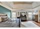 Bright primary bedroom showcasing hardwood floors, tray ceiling, and a calming color palette at 1229 Woodmere Dr, Loganville, GA 30052