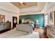 Bright main bedroom features a tray ceiling, ceiling fan, hardwood floors, and an accent wall at 1229 Woodmere Dr, Loganville, GA 30052