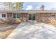 Backyard featuring a brick home with a concrete patio and large glass doors, offering potential for relaxing or entertaining at 3884 Rockey Valley Dr, Conley, GA 30288