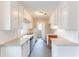 Galley kitchen with white cabinets, stainless steel dishwasher and neutral countertops at 3884 Rockey Valley Dr, Conley, GA 30288