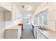 Galley kitchen with white cabinets, stainless steel dishwasher and neutral countertops at 3884 Rockey Valley Dr, Conley, GA 30288