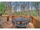 Back deck featuring wood planking and metal patio furniture, surrounded by a wooded area at 11853 Harbour Town Pkwy, Fayetteville, GA 30215