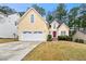 Inviting two-story home featuring a two-car garage, a red front door, and a well-manicured lawn at 11853 Harbour Town Pkwy, Fayetteville, GA 30215