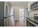 Well-lit kitchen with stainless steel refrigerator and granite countertops adjacent to living area at 1433 Dennis Dr, Decatur, GA 30032