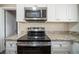 Modern kitchen features stainless steel microwave and range, granite countertops, and white cabinetry at 1433 Dennis Dr, Decatur, GA 30032