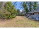A partially grassed backyard with a mix of green grass and brown grass and trees around the edges of the lot at 1925 Campbellton Sw Rd, Atlanta, GA 30311