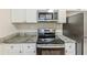 Modern kitchen with stainless steel appliances, granite countertops, and white cabinetry at 3192 Belfort Se Rd, Atlanta, GA 30354