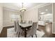 Formal dining room featuring an elegant chandelier, large windows, and seating for six at 3680 Falling Leaf Ln, Cumming, GA 30041