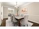 Formal dining room featuring an elegant chandelier, large windows, and seating for six at 3680 Falling Leaf Ln, Cumming, GA 30041