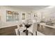 Bright dining room with a glass-topped table and white chairs, perfect for gatherings at 3680 Falling Leaf Ln, Cumming, GA 30041