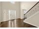 Elegant foyer featuring hardwood floors, a staircase with iron railings, and a view of the front door at 3680 Falling Leaf Ln, Cumming, GA 30041