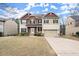 Charming two-story home featuring a stone facade, attached two-car garage, and well-manicured landscaping at 3680 Falling Leaf Ln, Cumming, GA 30041