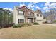 Elegant two-story home showcasing stone details, a two-car garage, and an attractive front yard at 3680 Falling Leaf Ln, Cumming, GA 30041