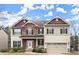 Charming two-story home featuring a stone facade, attached two-car garage, and a covered front porch at 3680 Falling Leaf Ln, Cumming, GA 30041
